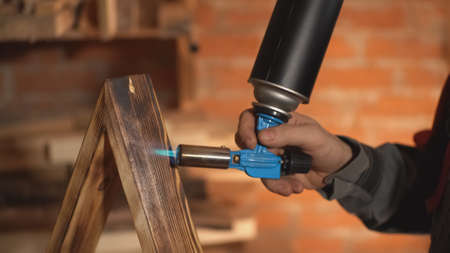 the master processes a wood product with a burner. close-upの写真素材