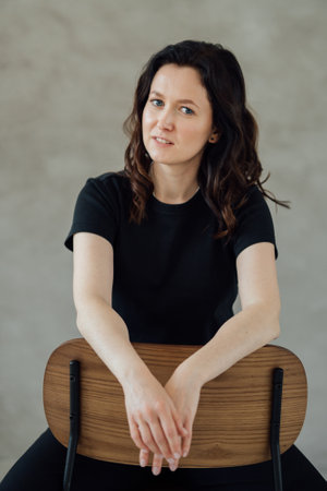 woman in black clothes. caucasian woman sits on a chair. portrait of a woman. High quality photo