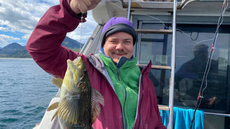 Fisherman caught a perch with a fishing rod. Boat trip on a boat along the Avacha Bay. Fishing in...