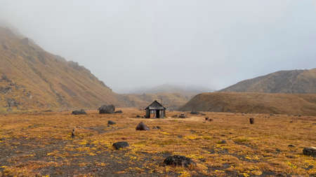 A small wooden house in the vastness of autumn Kamchatka. Trekking in the Klyuchevskoy volcano park. Travel to the Kamchatka Peninsula.の写真素材