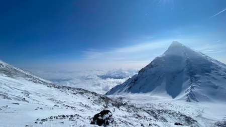 A fantastic view above the clouds of the volcanoes of central Kamchatka at an altitude of 3900...