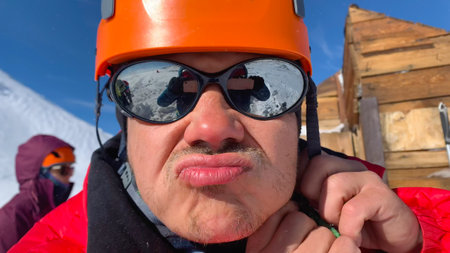 Cool brutal unshaven traveler in a helmet and sunglasses close-up. Trekking in the Klyuchevskoy...
