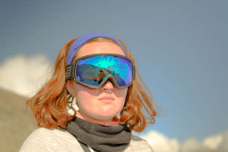 Portrait of a red-haired woman in a ski mask. Tourist climber on the background of mountains. Climbing Kazbek from the north, from the side of Russia.の写真素材