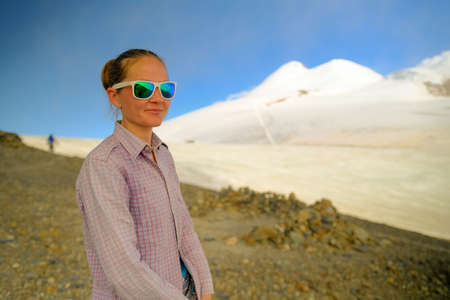 Tourist climber on the background of Mount Kazbek. Portrait of a woman in mountain sunglasses....