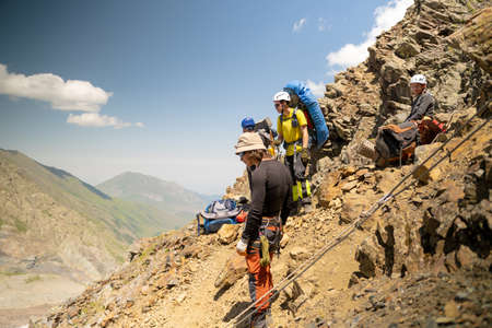 Mountain tourists are sitting on a rock. Climbing Kazbek from the north, from the side of Russia....