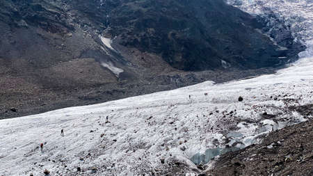 Climbers are walking along the Miley glacier. Mountain landscape of North Ossetia. Climbing Kazbek from the north, from Russia. Hike across the Caucasus.の写真素材