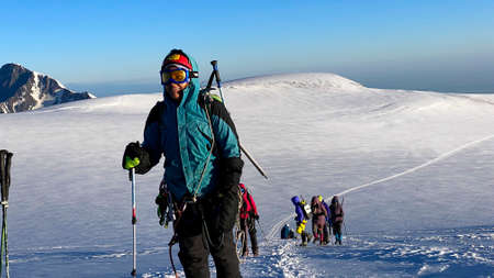 Happy climbers go uphill. Mountain landscape of North Ossetia. Snow-capped mountains. Climbing...