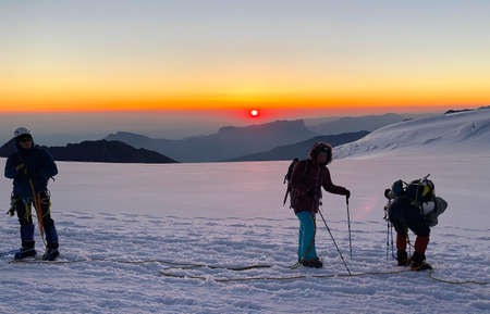 Climbers in the mountains at sunrise. Climbing Kazbek from the north, from Russia. Hike across the...