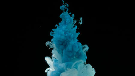 Cosmic magic background. Blue and white watercolor ink in water on a black background. Waves and...