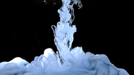 Blue-gray ink cloud. Waves and drops of blue-gray colors. Beautiful abstract background. Amazing space magic background. Light blue-gray watercolor ink in water on a black background.の写真素材