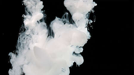 White cloud of ink on a black background. Beautiful abstract background. White watercolor ink in...