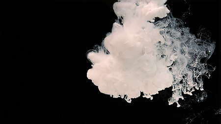 Waves of milky ink and splashes of white paints in the water. White cloud of ink on a black...