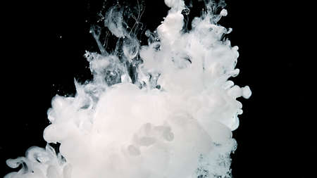 White cloud of ink on a black background. White watercolor paints in water. Cosmic magic abstract background.の写真素材