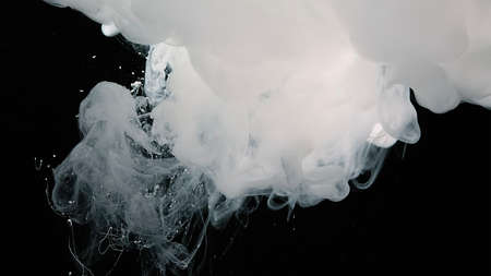 White watercolor paints in water. White cloud of ink on a black background.