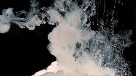 Fantastic white abstract background. White watercolor ink in water on a black background. Waves of...