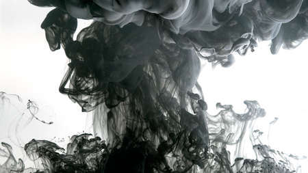Environmental pollution concept. Desktop wallpaper. Black cloud of ink on a white background. Creative hyptonic background. Black watercolor paints in water on a white background.の写真素材