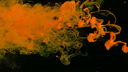 Awesome abstract background. Colored ink cloud on gray background. Yellow watercolor paints in water on a black background. Desktop wallpaper. Yellow cloud of ink on a black background.の写真素材