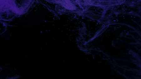 Violet watercolor paints in water on a black background. Awesome abstract background. Beautiful wallpaper for your desktop. Violet cloud of ink on a black background. Drops of purple ink in water.の写真素材