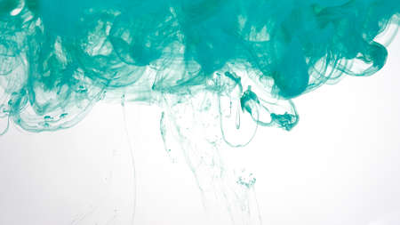 Colored cloud of ink on a white background. Mint green watercolor ink in water on a white background. Beautiful abstract background. Mint green dyes are mixed in water.の写真素材