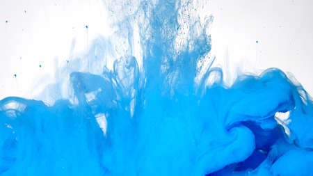 Blue watercolor ink in water on a white background. Beautiful abstract background. Blue paints are mixed in water. Colored cloud of ink on a white background.の写真素材