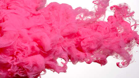 Pink cloud of ink on a white background. Awesome abstract background. Drops of pink ink in water. Pink watercolor ink in water on a white background. Colored acrylic paints in water.の写真素材