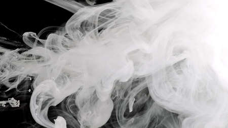 Space background. White cloud of ink. White ink is mixed in water on a black background. Amazing...