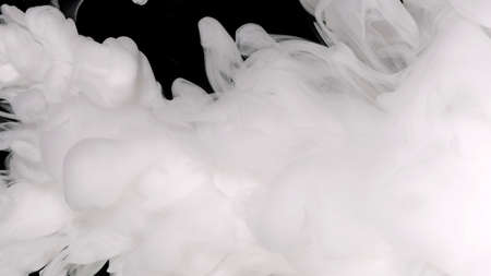 Beautiful milky white awesome abstract background. White acrylic ink in water on a black background. Environmental pollution concept. White cloud of ink. Relaxing meditative background.の写真素材