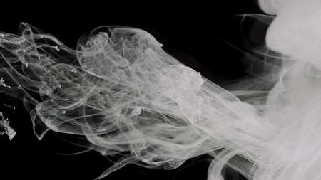 White ink in water on a black background. Milky white awesome abstract background. White cloud of...