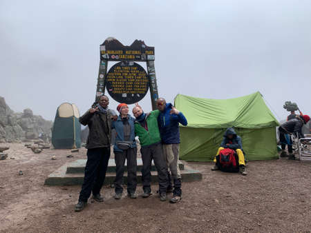 Kilimanjaro, Tanzania - December 29, 2021: A group of white tourists stand at the Stella Lava Tower Camp with their black guides. Climbing Kilimanjaro. mountain landscape.のeditorial素材