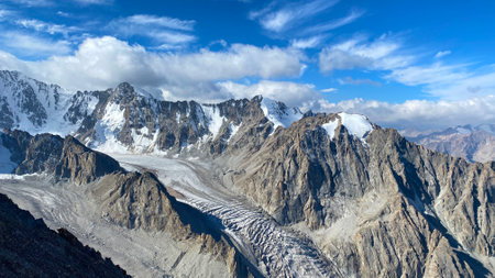 View of the snow-capped peaks of the Kyrgyz mountains. Rocks, glacier, blue sky and white clouds. beautiful mountain scenery. Ala Archa National Park in Kyrgyzstan. Active summer holidays.の写真素材