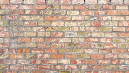 A beautiful wall of old multicolored shabby bricks. Texture of dilapidated brickwork. Construction...