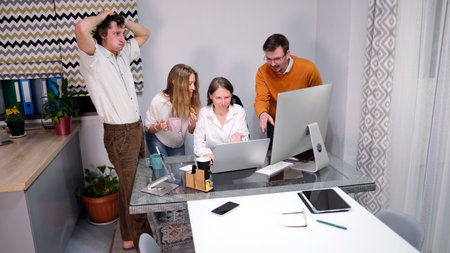 A puzzled team of office staff helps their boss with a project. A group of people gathered around...