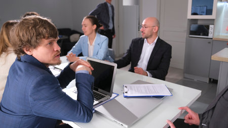 A successful lawyer provides advice to a business firm in a conference room. A group of office...