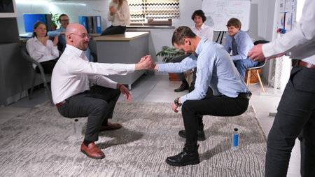 A fun office team building game. Two businessmen locked hands and keep the balance trusting each...