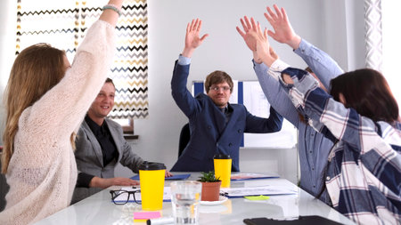 Teamwork. The concept of celebrating the company's birthday. A group of people are raising their...