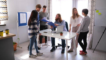 The boss called the company's staff to a morning meeting. Young employees communicate with each...