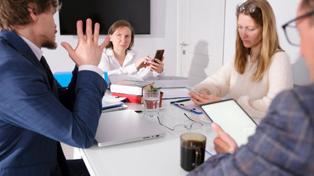 A group of young people are sitting at a table in the conference room of a family office. Teamwork....