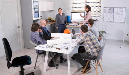 The male chief engineer and his female assistant present a new architectural project to the Board of...
