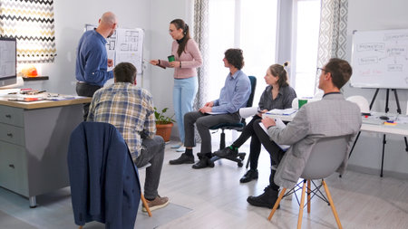 A man and his female assistant are making a presentation. A group of people gathered in a conference...