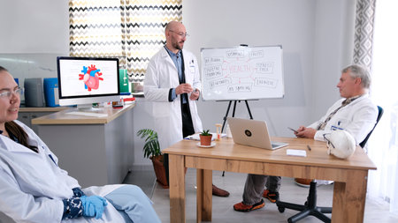 A personable man in glasses and a white lab coat leads a presentation in the field of cardiac...
