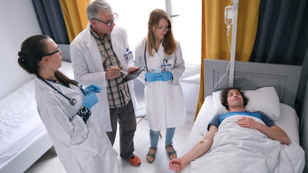 The guy is lying on an IV in a medical clinic. Three competent doctors are standing by his bed and...