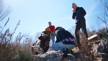 A group is building a bonfire for a picnic. Two women and two men are actively spending the weekend...