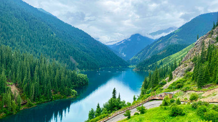 Kolsai lakes are one of the most beautiful places of the Kazakh nature. Serene view of the blue lake in the mountains covered with green forests. A mountain range with a lake in the valley.の写真素材