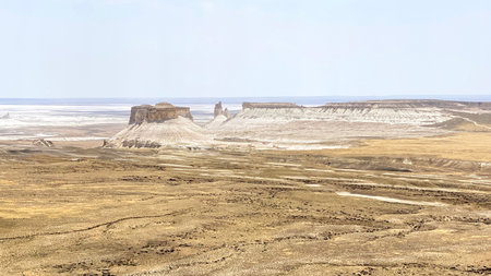 A bleak, lifeless landscape with several sandy mountain salt formations. The view of the Bozzhyra tract is an amazing natural phenomenon in Kazakhstan. Attraction of Mangystau.の写真素材