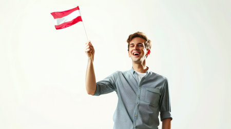 A man holds the red-white-red flag of Austria in his hands and smiles. A cheerful tourist with the flag of Austria on a white background. The concept of immigration. Independence Day. Patriotismの素材