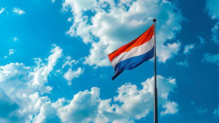 The flag of the Netherlands is flying in the sky. The striped red, white and blue Dutch flag hangs on the flagpole. Travel and tourism. Independence Day. Immigration. Obtaining citizenship. Study and workの素材