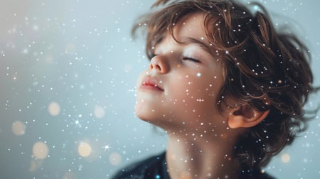 A cute little boy raised his face to the sky, snowflakes are falling around him. The idea of a miracle and peace when a child enjoys the beauty of snowfall. Childhood. The child's future. The innocent soul of a kidの素材