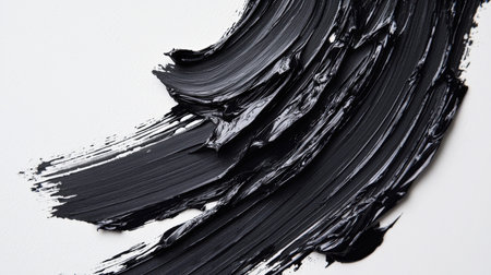 A smear of black paint on a white background. An element for the design. Space backdrop. Abstract oil background. Textural smears of black ink. The black paint gives the impression of depthの素材