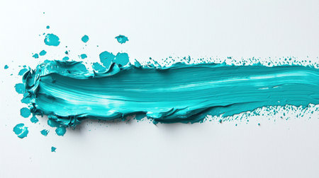 Abstract brushstroke with a blue brush on a white background. The smear turns out to be long and sweeping with frozen splashes of turquoise paint. The marine concept. The scene is somewhat chaotic and messyの素材