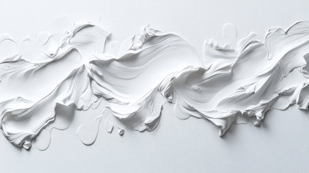 Thick strokes of a white brush on the canvas. A white expressive line drawn with white paint by hand. The line is long, textured, and there is a lot of white paint on it. An element for the design.の素材